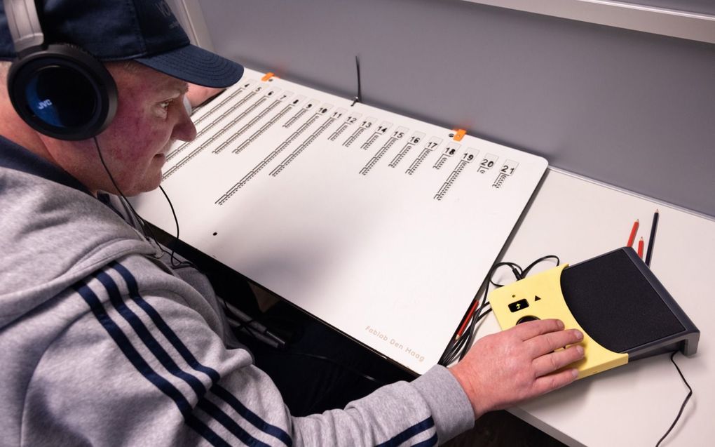 De blinde Marcel Boer brengt op een oefenstemdag met behulp van een stemmal en een soundbox zijn stem uit. beeld Dirk Hol