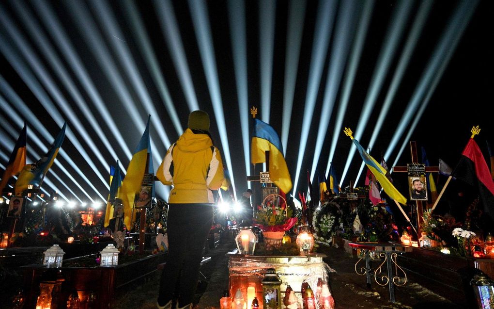 Een symbolische "straal van de herinnering" schijnt op de Lychakiv begraafplaats in Lviv boven de graven van Oekraïense soldaten die stierven in de oorlog met Rusland. beeld AFP, YURIY DYACHYSHYN