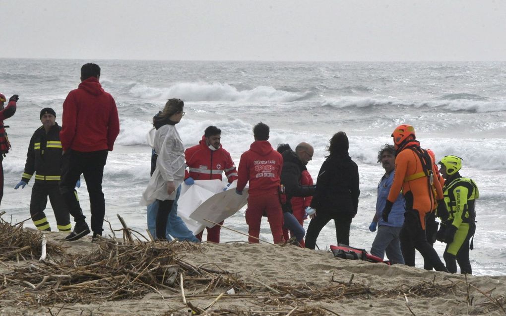 Lichamen  worden geborgen op het strand van Cutro. Beeld EPA, GIUSEPPE PIPITA