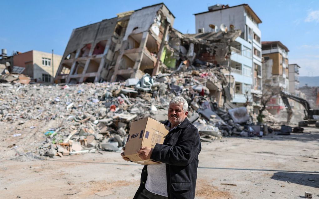 Een man draagt een doos met hulpverleningsproducten in het rampgebied in Turkijke. beeld ANP