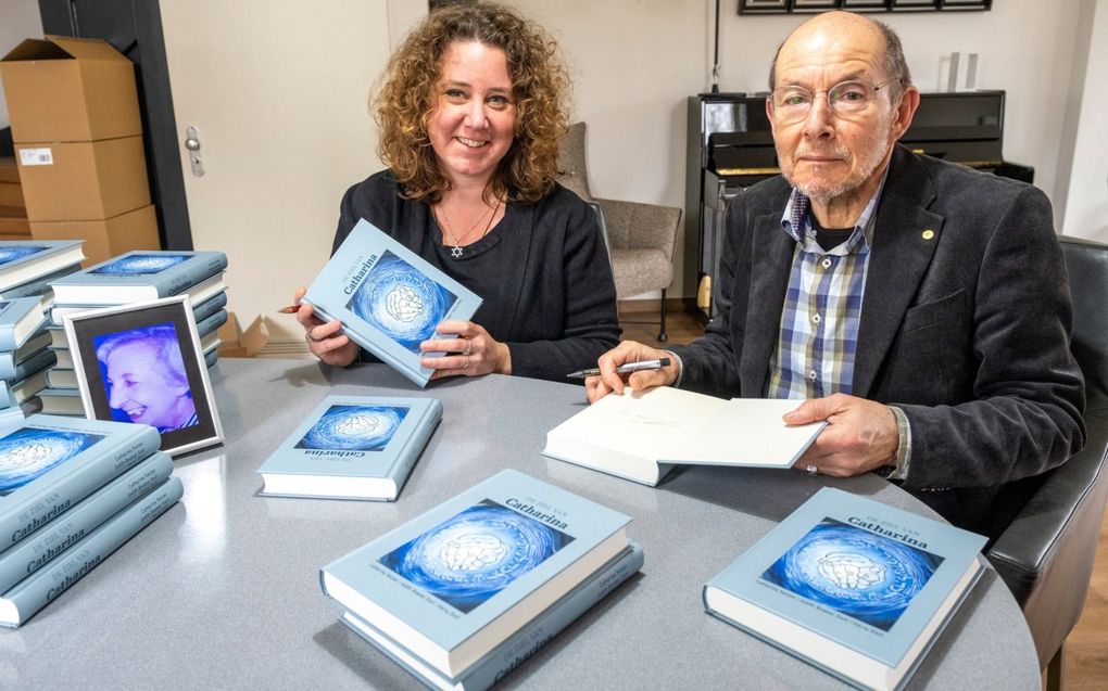 Judith Boekel was vrijdag in Haamstede om met haar vader, ds. H.E. Smit, hun boek te signeren. Op tafel het portret van hun moeder en oma. beeld Dirk Jan Gjeltema