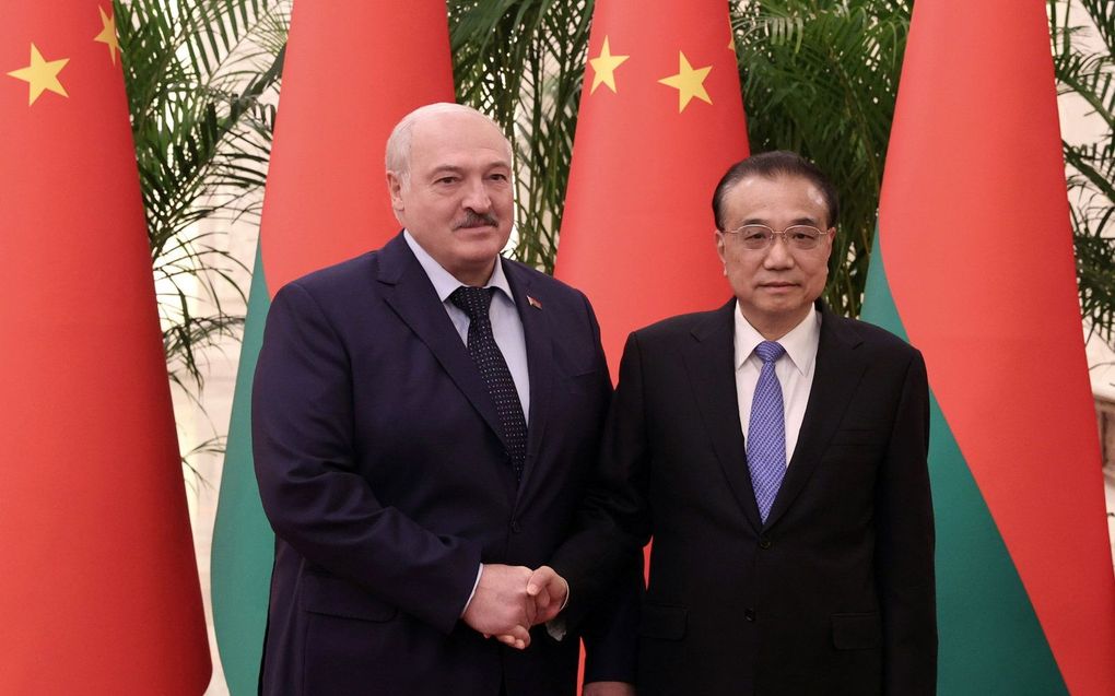 De Wit-Russische president Aleksandr Loekasjenko (l.) en de Chinese premier Li Keqiang (r.) poseren voor een handdruk tijdens hun ontmoeting in Peking. beeld EPA