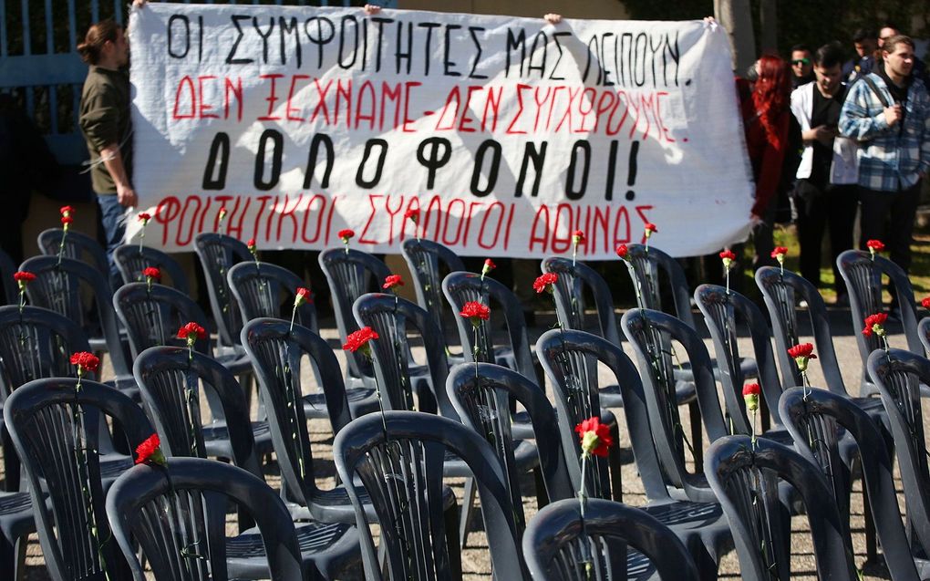 Maandag hebben demonstranten in Athene lege stoelen met rode anjers neergezet voor het gebouw van het transportministerie, als symbool voor de slachtoffers van de treinramp in Griekenland. beeld EPA, Orestia Panagiotou