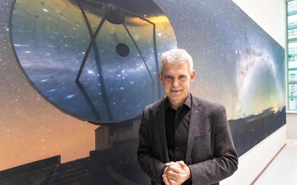 Astronoom Heino Falcke poseert voor een poster met een ruimtetelescoop op de faculteit sterrenkunde van de Radboud Universiteit in Nijmegen. beeld RD, Anton Dommerholt