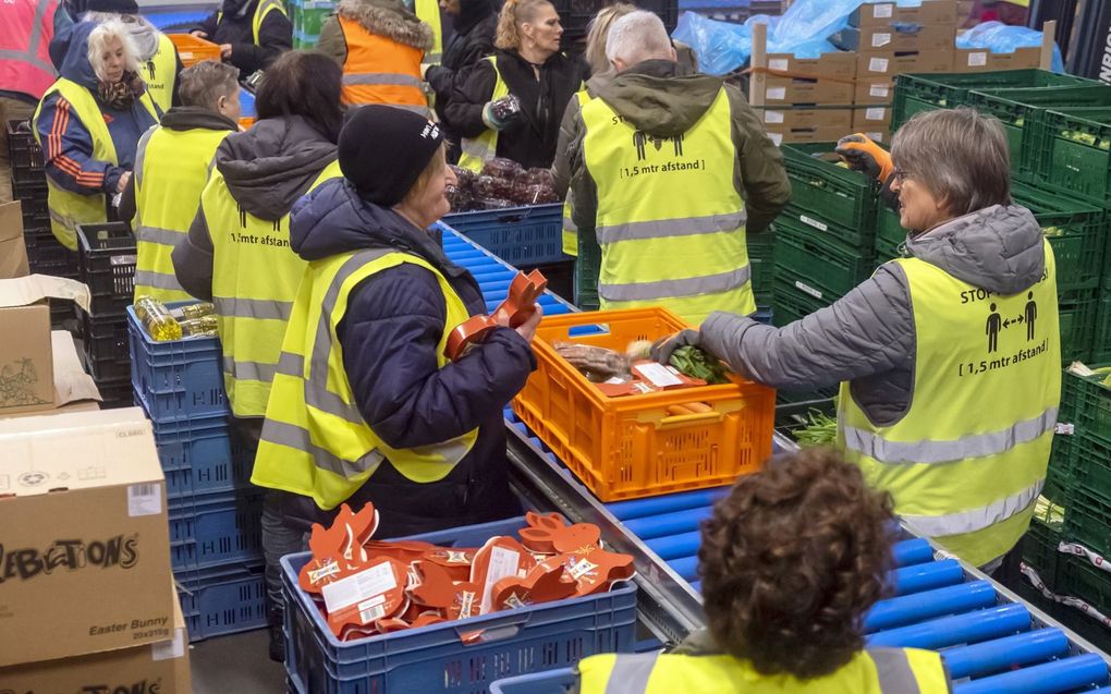 Medewerkers van de Rotterdamse Voedselbank vullen kratjes met producten. beeld ANP, Hans van Rhoon