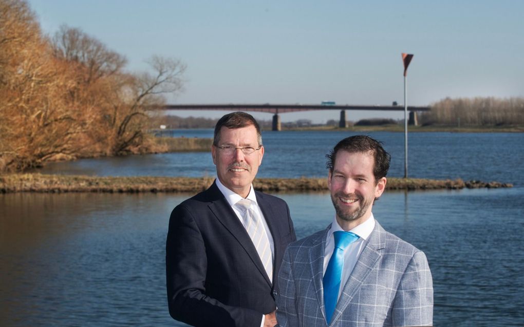 De gedeputeerden Arne Schaddelee uit Utrecht (rechts) en Peter van ’t Hoog uit Gelderland met achtergrond brug tussen Rhenen en Kesteren waar de provincies in de achterliggende jaren over ruzieden.  beeld William Hoogteyling