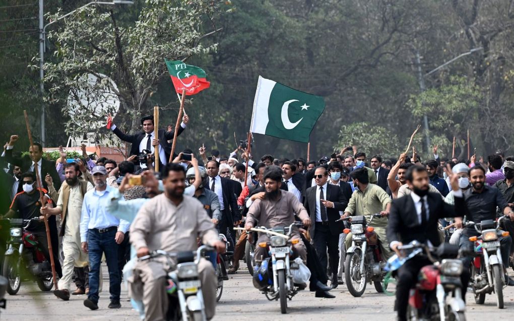 Aanhangers van de voormalige premier van Pakistan, Imran Khan, blokkeerden in Lahore een weg in de buurt van de residentie van Khan. beeld AFP, Aamir Qureshi