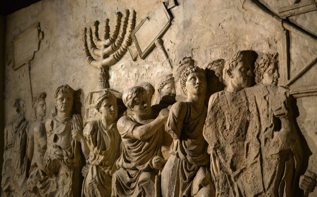 Reliëf aan de binnenzijde van de boog van Titus, met daarop Romeinse soldaten die onder meer de menora en de tafel der toonbroden uit de tempel van Jeruzalem als oorlogsbuit meedragen. beeld colosseum.info