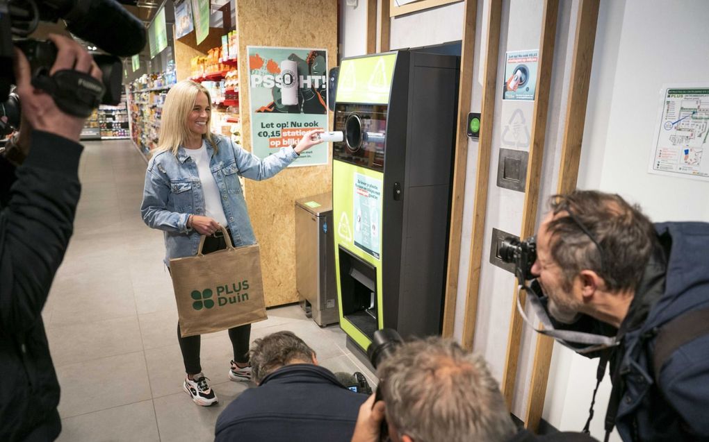 Een consument overhandigt symbolisch een blikje bij een inzamelpunt in een supermarkt in Almere, bij de aftrap voor de invoering van 15 eurocent statiegeld op blikjes per 1 april. De invoering van statiegeld moet voorkomen dat blikjes in de natuur worden weggegooid. Ook moet de maatregel het recyclen verbeteren.  beeld ANP, Jeroen Jumelet