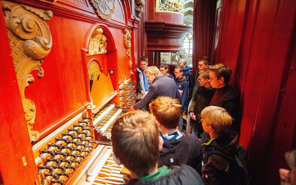 Jongeren rond de speeltafel van het wereldberoemde Müllerorgel in de Haarlemse Bavo tijdens de trip van StayTuned.nu in oktober 2022. beeld Albert Allema