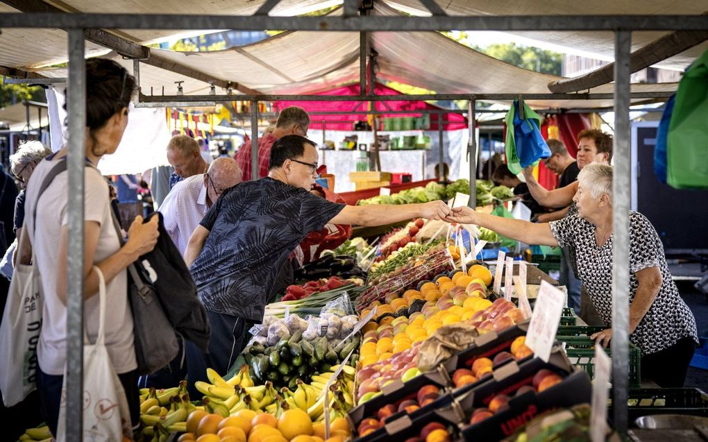 Mensen doen boodschappen op de Markt op het Afrikaanderplein in Rotterdam. beeld ANP RAMON VAN FLYMEN