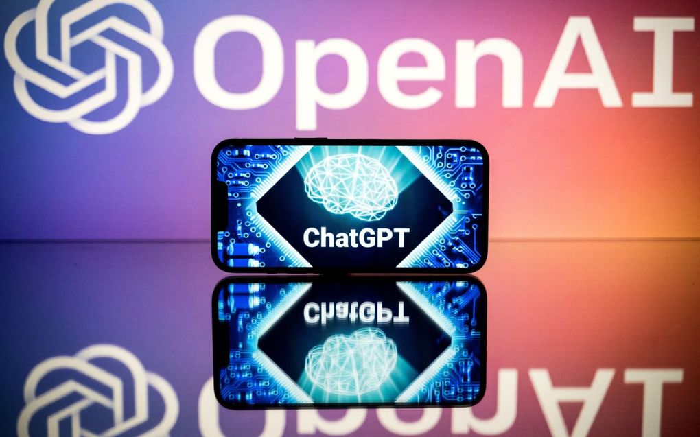 Het logo van ChatGTP op een smartphone en het logo van OpenAI op de achtergrond. beeld AFP, Lionel Bonaventure