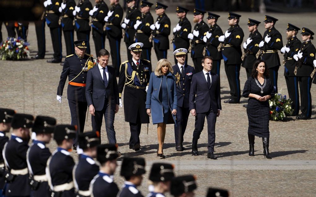 De Franse president Emmanuel Macron en zijn vrouw Brigitte leggen in aanwezigheid van Premier Mark Rutte en burgermeester Femke Halsema een krans bij het Nationaal Monument op de Dam. Het presidentieel paar brengt een tweedaags staatsbezoek aan Nederland. beeld ANP OLAF KRAAK