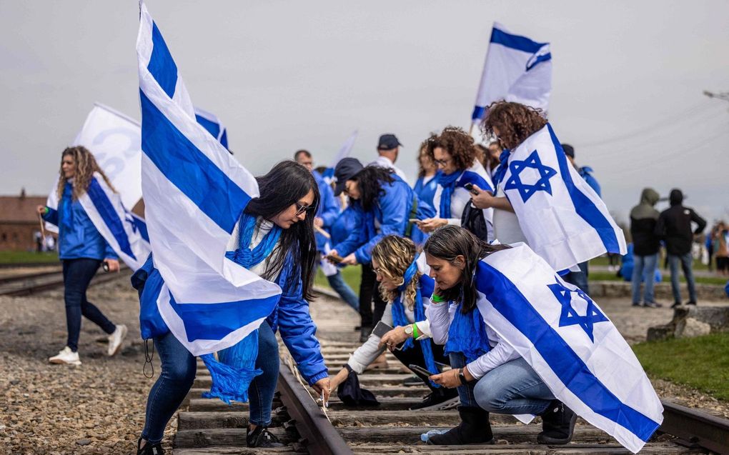 Deelnemers aan de jaarlijkse "Mars van de Levenden" lopen langs de treinsporen naar kamp Birkenau, onderdeel van het voormalige nazi-concentratiekamp Auschwitz-Birkenau in het dorp Brzezinka bij Oswiecim, Polen. De mars markeert de 75e verjaardag van de staat Israël, de 80e verjaardag van de opstand in het getto van Warschau en de 35e verjaardag van de mars zelf. beeld AFP, Wojtek RADWANSK