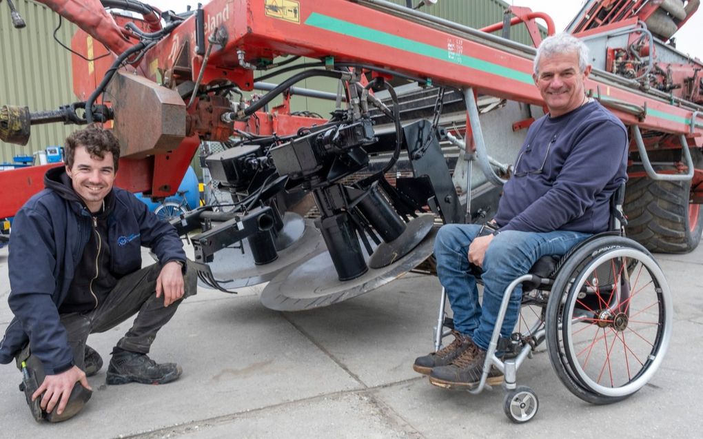 Bennie Poppe (rechts) met zijn zoon Michiel voor een rooimachine. beeld Dirk-Jan Gjeltema