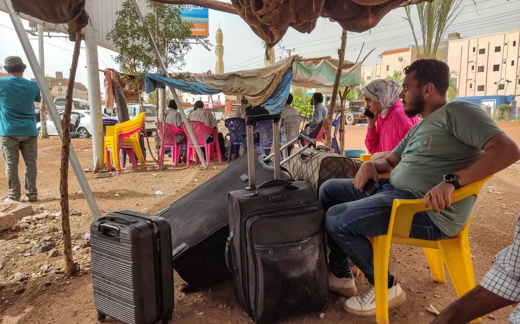 Mensen die Sudan willen verlaten, wachten in Khartoem op een bus. beeld AFP