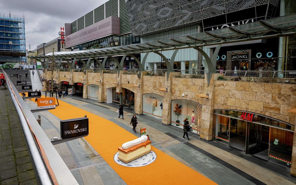 Een oranje loper met een oranje tompouce in de koopgoot ter voorbereidingen op Koningsdag in het centrum van Rotterdam. beeld ANP, ROBIN VAN LONKHUIJSEN