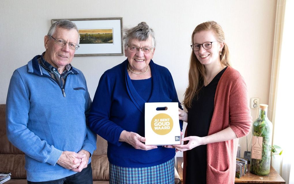 Annerike Bouman-ten Hove geeft opa en oma Van den Brink een notenpakket. „Ze zijn dankbaar dat ze nog voor elkaar mogen zijn.” beeld RD, Anton Dommerholt