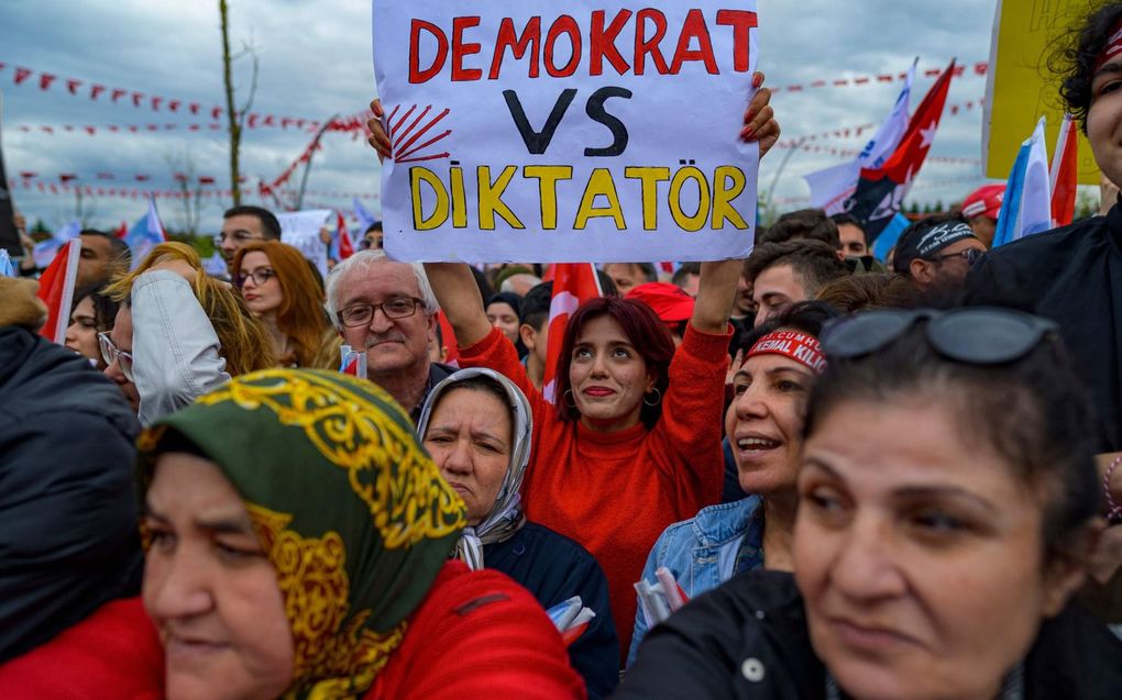 Een aanhanger van presidentskandidaat Kemal Kilicdaroglu houdt tijdens een verkiezingsbijeenkomst een papier in de hoogte met daarop de tekst ”Democraat vs Dictator”. Met de democraat wordt Kilicdaroglu bedoeld, met de dictator de zittende president Recep Tayyip Erdogan. beeld AFP, Yasin Akgul