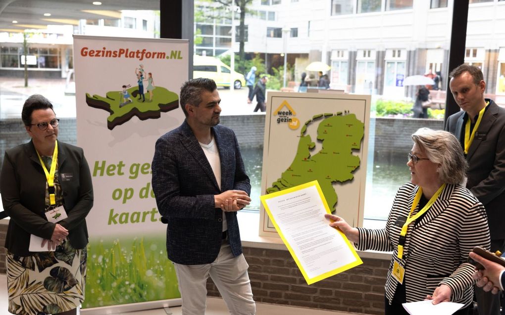 Yvonne Koopman overhandigt de petitie van GezinsPlatform.nl aan commissievoorzitter Kuzu (Denk). beeld Dirk Hol