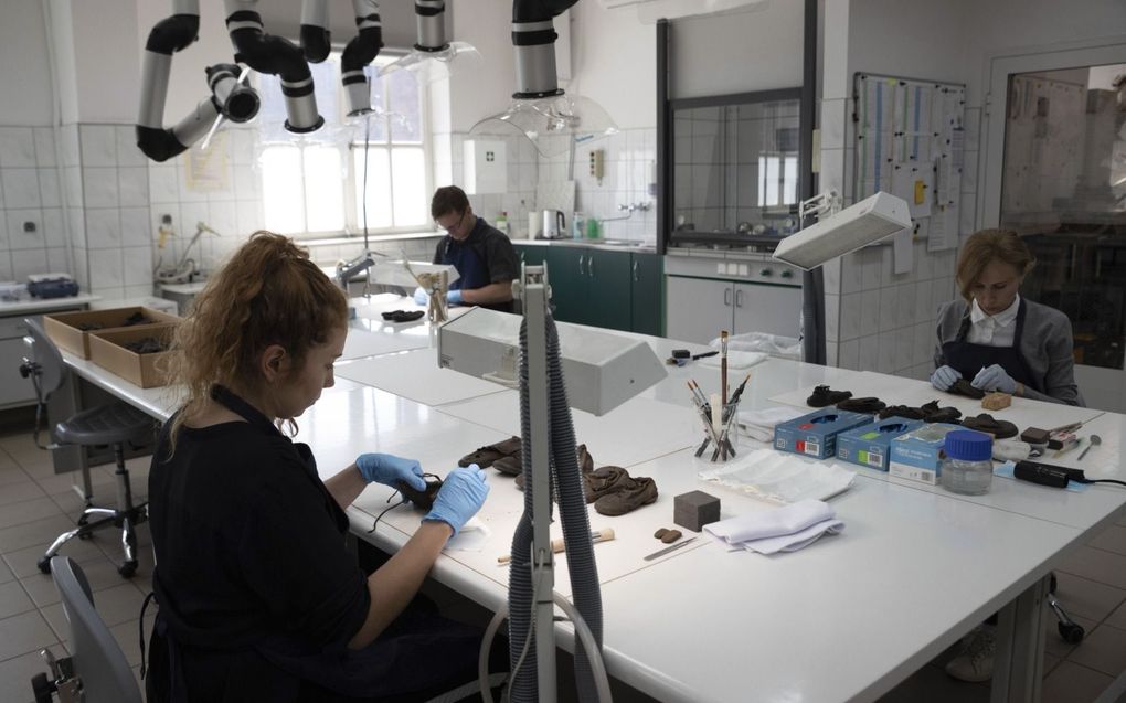 Specialisten aan het werk in het laboratorium van Auschwitz om kinderschoenen te conserveren. beeld AP, Michal Dyjuk