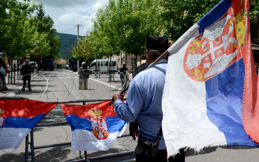 Demonstrant met Servische vlag in de noordelijke Kosovaarse plaats Zvecan, woensdag. Tegenover hem staan militairen van de door de NAVO geleide vredesmacht KFOR. beeld AFP 