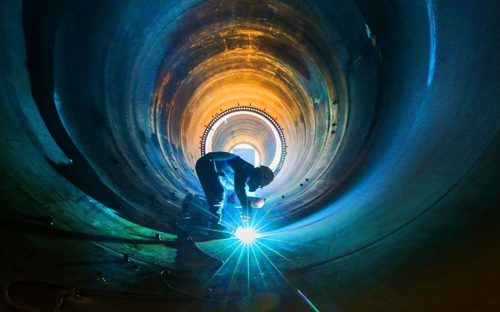 Een werknemer werkt aan een windturbinetoren in een fabriek in Lianyungang, China. beeld AFP, STR