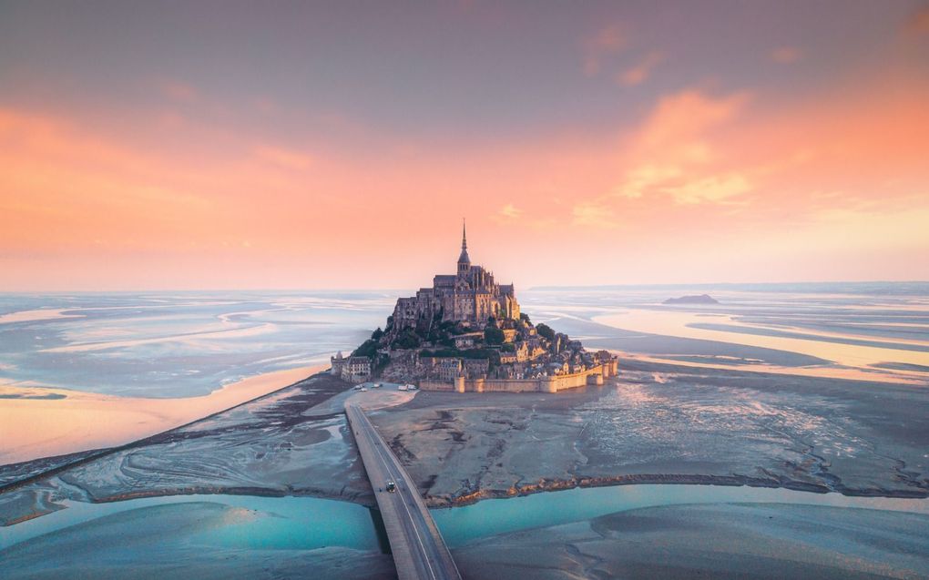 Het getij speelt met het zand rond het eiland Mont Saint-Michel voor de kust van Normandië. beeld iStock