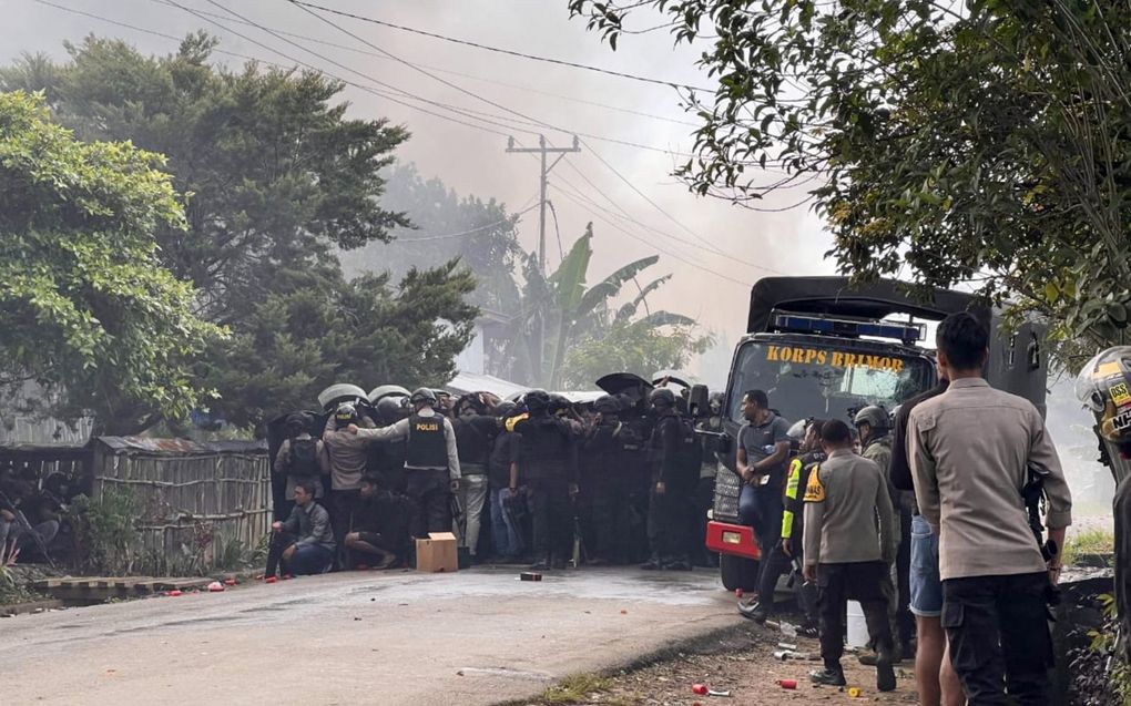 Oproerpolitie houdt een mensenmenigte tegen in Wamena, in het oosten van Papoea, 23 februari. beeld AFP, Aciz Razi