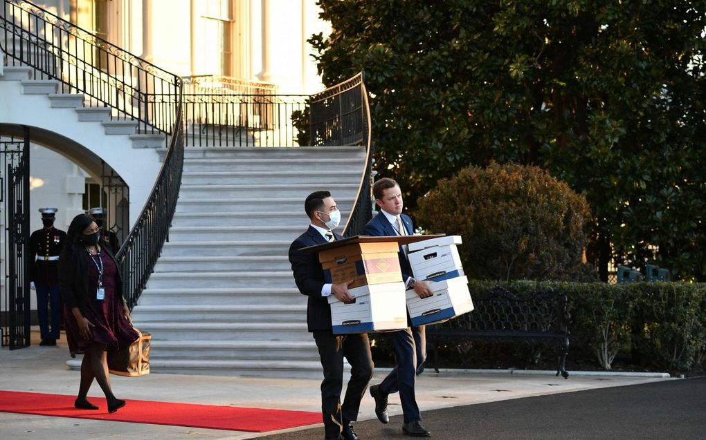 Assistenten van Donald Trump verhuizen dozen uit het Witte Huis op 20 januari 2021, de laatste dag dat Trump president was. Trump wordt ervan verdacht geheime documenten mee naar huis te hebben genomen. beeld AFP, Mandel Ngan