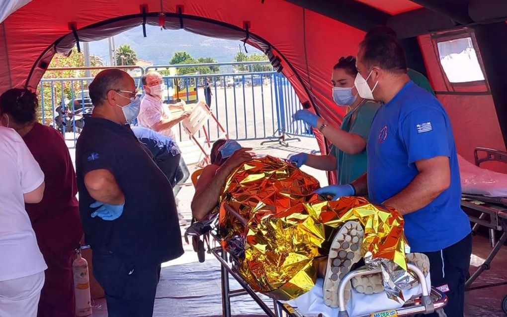 Medewerkers van het Rode Kruis ontfermen zich over een overlevende van de scheepsramp. beeld EPA, Bougiotis Evangelos​