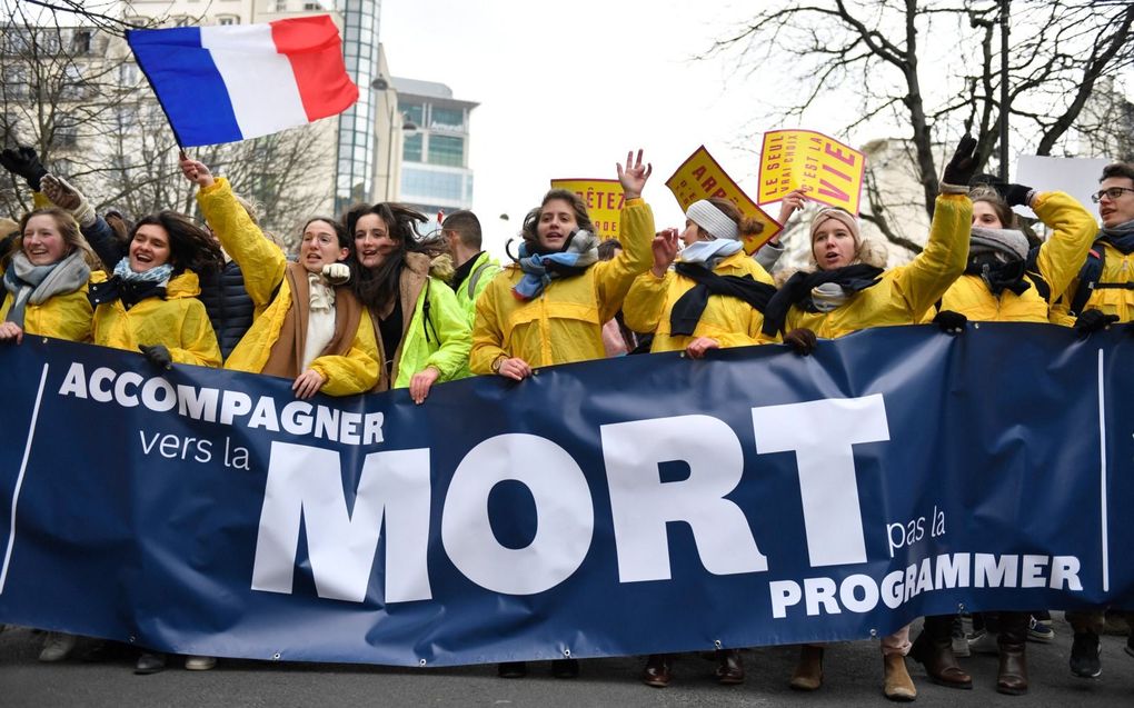 Demonstranten dragen een spandoek met de tekst “zorg rond de dood, geen actieve levensbeëindiging“ tijdens een mars voor het leven in Parijs op 22 januari 2023. beeld AFP, Julien de Rosa