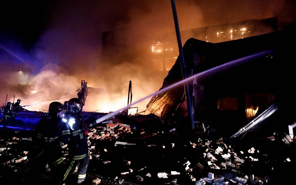 Brandweerlieden doven de vlammen van een hotel dat in brand is gestoken tijdens protesten in Roubaix, Noord-Frankrijk. beeld AFP, Kenzo TRIBOUILLARD