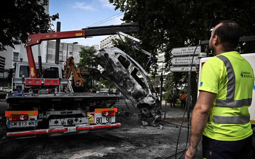 Een verbrande auto wordt afgevoerd in  Aubiers, een wijk van Bordeaux. beeld AFP, Philippe LOPEZ