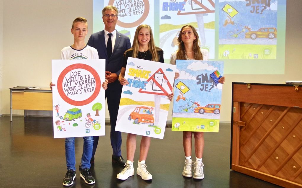 Hanna de Korte (midden), winnares van de hoofdprijs van de posterontwerpwedstrijd, met de andere winnaars Jette Anthonise en Harm Boone. Gedeputeerde Harry van der Maas reikte de prijzen uit. beeld Van Scheyen Fotografie