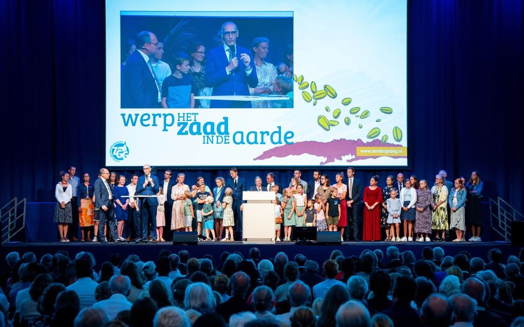 De aanwezige werkers van ZGG staan op het podium om toegezongen te worden. Achter de tafel wordt zendingswerker Dick Korpel (r) uit Ecuador ondervraagd door ZGG-voorlichter Frans van Grol. beeld Michael Ivanov