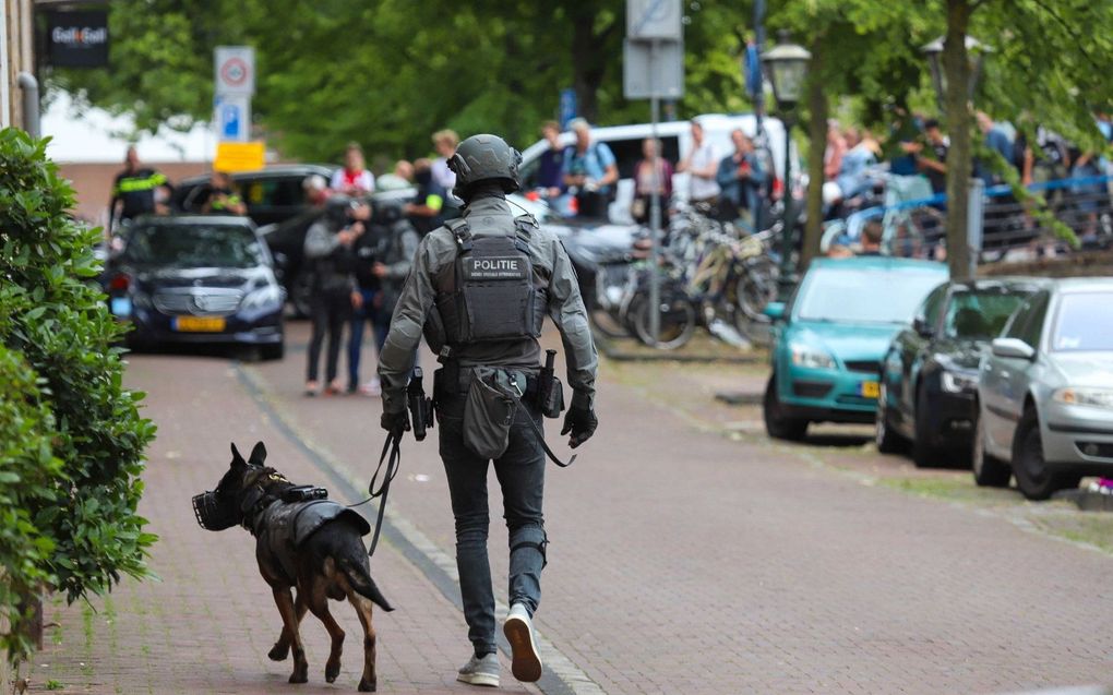 Een lid van het arrestatieteam loopt met een politiehond door het centrum van Leiden, na de dodelijke steekpartij in het centrum. beeld ANP, Mediatv Wouter Hoeben