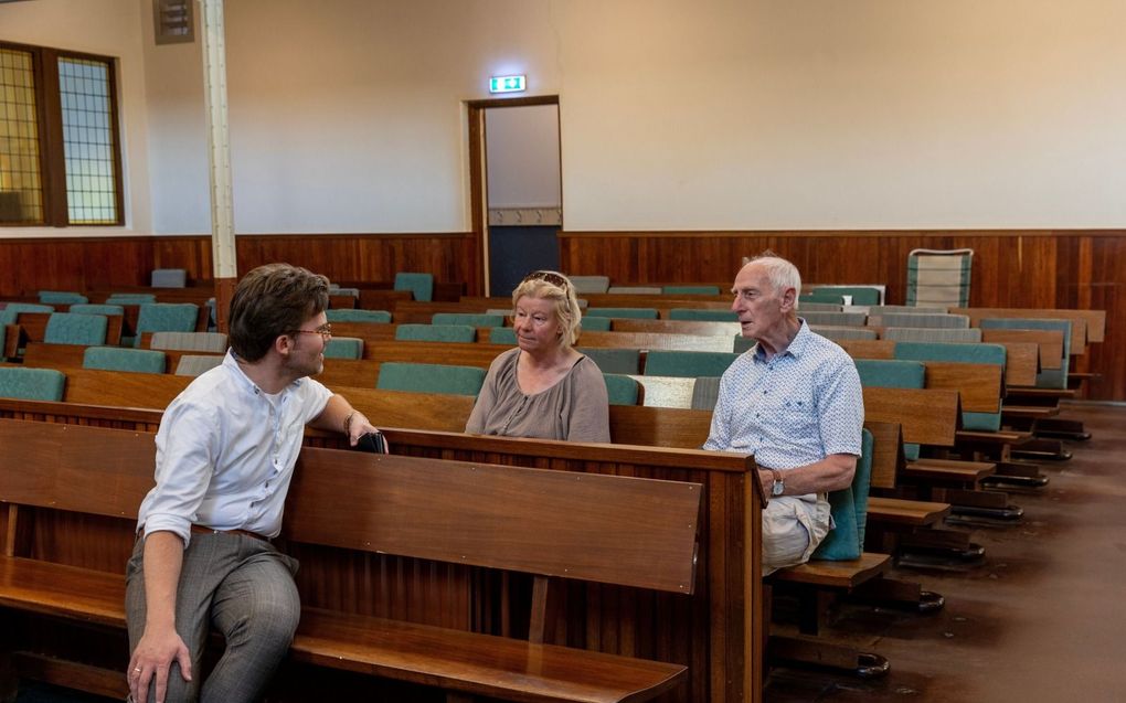 Ds. L. Krooneman (l.) in gesprek met een belangstellend echtpaar, beeld Robert Vos