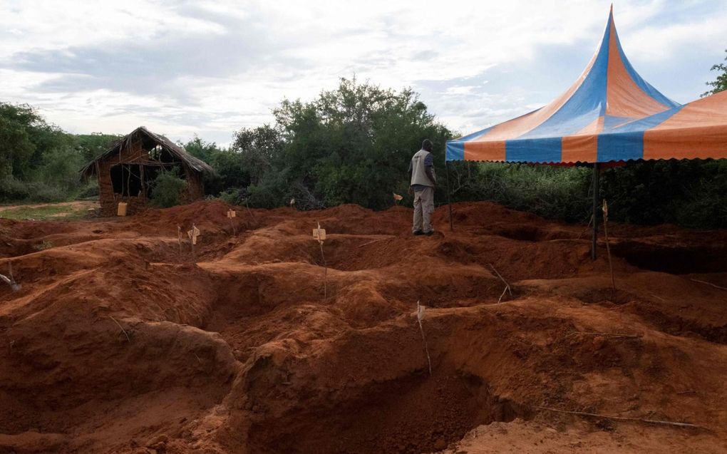 Een beambte van het Keniaanse directoraat voor onderzoek naar criminaliteit (DCI) bezoekt de locatie in Shakahola waar massagraven zijn aangetroffen, vlakbij de kuststad Malindi. beeld AFP, Yasuyoshi Chiba