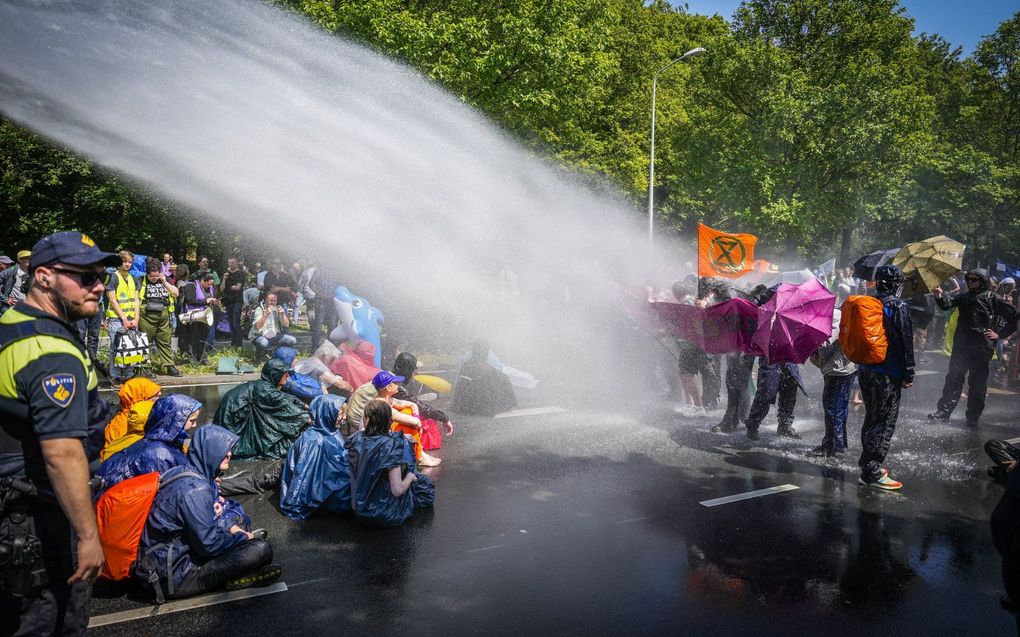 De politie zet een waterkanon in tegen Activisten van Extinction Rebellion. beeld ANP PHIL NIJHUIS