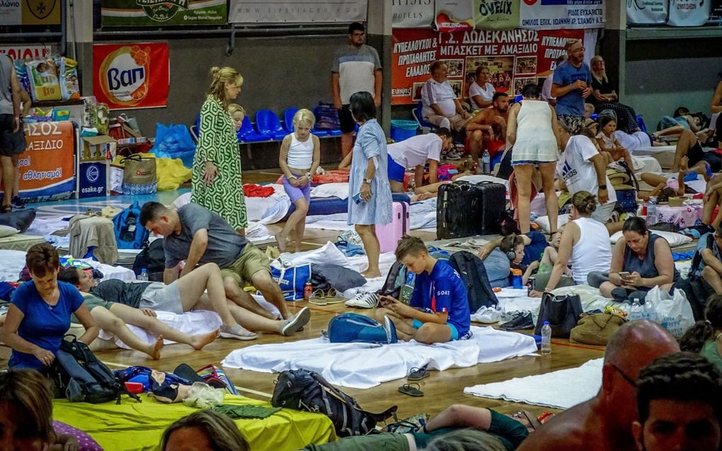 Gestrande reizigers worden op Rhodos opgevangen in een sporthal. Duizenden mensen op het eiland zijn geëvacueerd. beeld AFP, Stringer