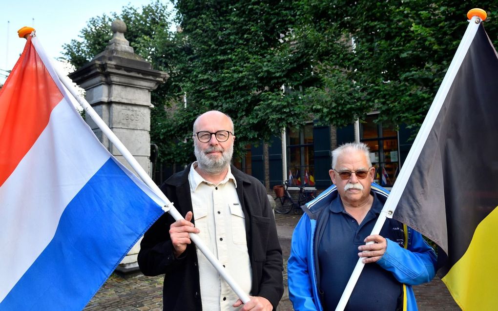 Wim Vervoort uit België (met Nederlandse vlag) en Martin van Gool uit Nederland (met Belgische vlag) hebben dagelijks te maken met de grensperikelen. beeld Erald van der Aa