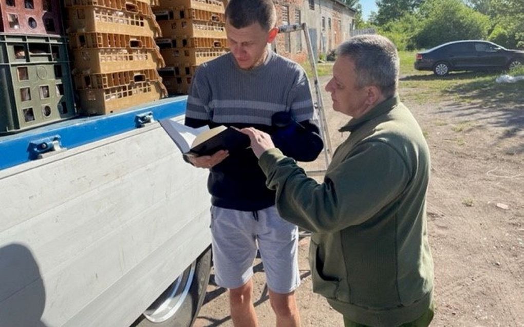 Een inwoner van Oekraïne leest in een Bijbel die hij heeft gekregen. beeld GBS