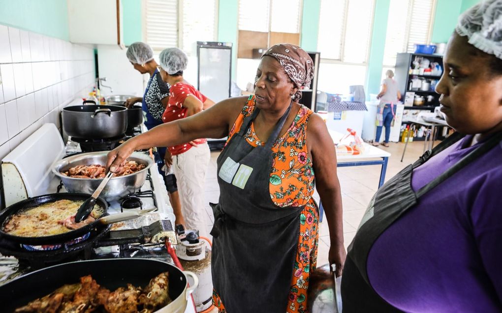 Een vrouw bereidt eten in de keuken van de Daily Meal Program. beeld Maarten Boersma