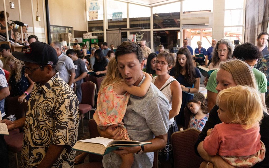 Kerkdienst van de Lahaina's Grace Baptist Churc, zondag in Wailuku, Maui, in een koffiewinkel. De eigen kerk in Lahaine is, net als de rest van het stadje, verwoest door bosbranden. beeld AFP, Yuki IWAMURA