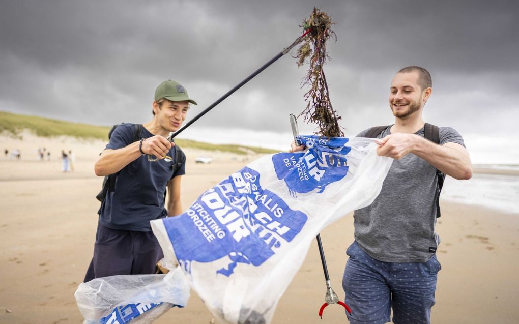 Vrijwilligers ruimen het strand op tijdens de tiende Beach Cleaunup. beeld ANP, Freek van den Bergh