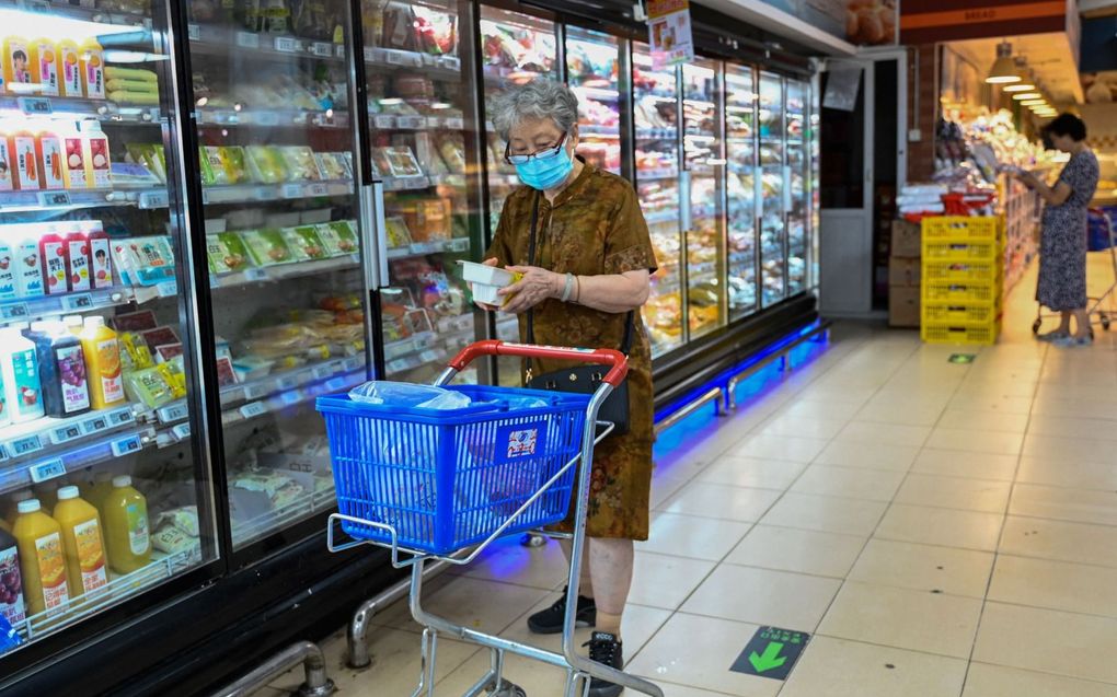 Chinezen houden de hand op de knip en daardoor leven er wereldwijd zorgen over de staat van de economie van het land. Foto: een vrouw voor het diepvriesschap in een Pekingse supermarkt. beeld AFP, Pedro Pardo