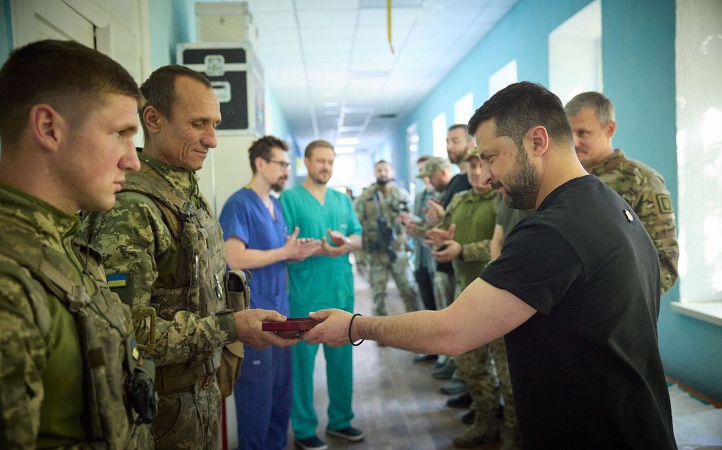 De Oekraïense president Zelensky reikt een medaille uit aan een militair. beeld EPA