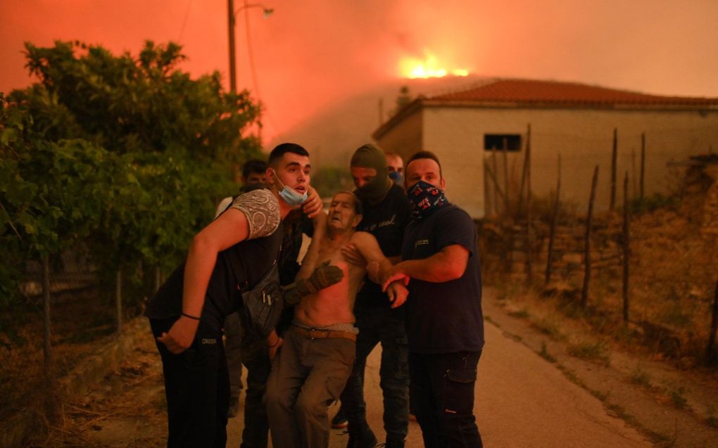 Evacuatie van een oudere man in Avantas. beeld EPA, DIMITRIS ALEXOUDIS