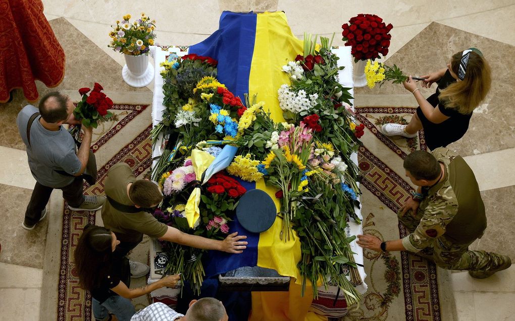 Familie, vrienden en kameraden leggen bloemen op de kist van de Oekraïense gevechtspiloot Andri Pilsjtsjykov, in de Kathedraal van de Verrijzenis van Christus in Kiev. beeld EPA, CATHAL MCNAUGHTON